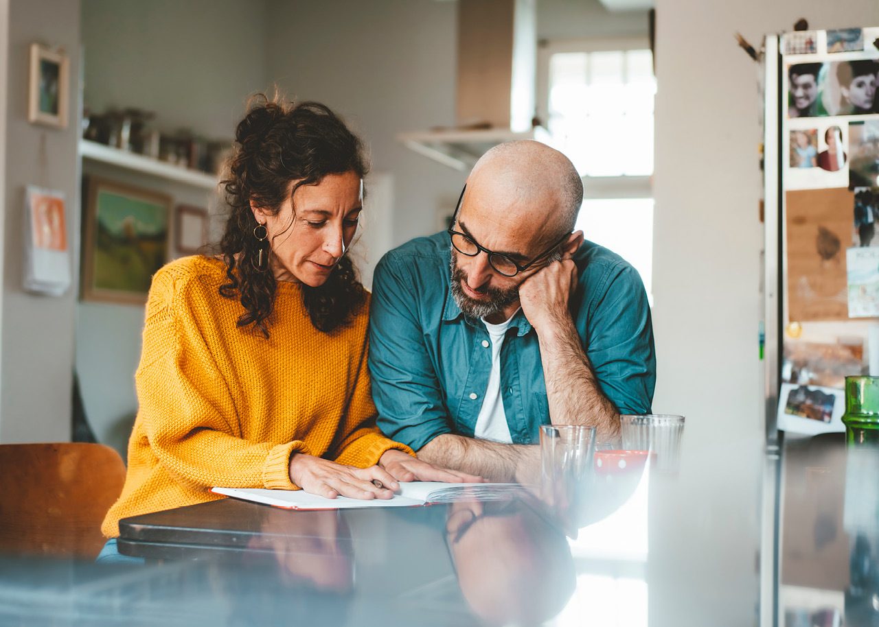 Couple sitting and reviewing bills at home